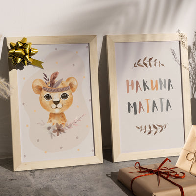 Zwei gerahmte Kinderzimmer-Poster mit Löwenmotiv und 'Hakuna Matata'-Spruch, dekoriert mit Geschenkband und Schleife.