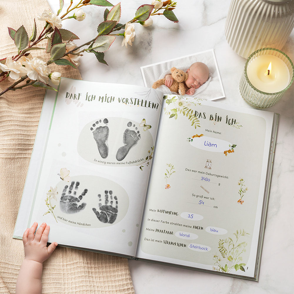 Geöffnetes Eulentaler Babyalbum „Mein erstes Jahr“ mit Hand- und Fußabdrücken, persönlichen Geburtsdaten und liebevoll gestalteten Erinnerungsseiten.
