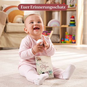 Baby hält eine Meilensteinkarte für das erste eigenständige Sitzen. Perfekt, um kostbare Erinnerungen festzuhalten.